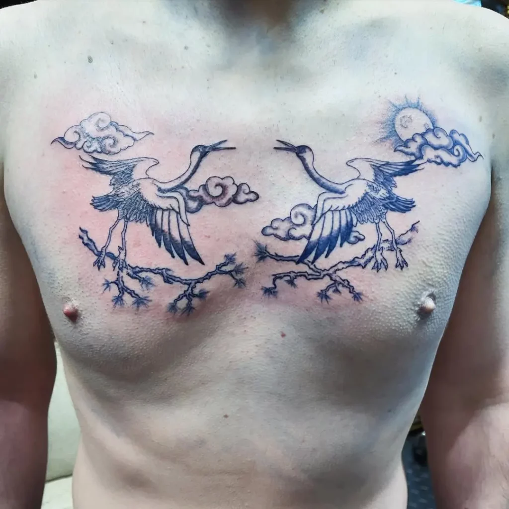 Photo d'un tatouage de grues bleues sur un torse