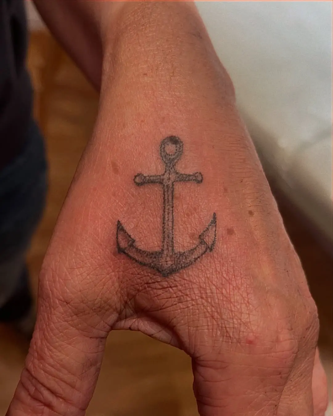 Ancre tatouée avec la technique du handpoke sur une main