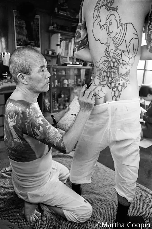 Photo de Martha Cooper d'un artiste tatoueur en plein travail