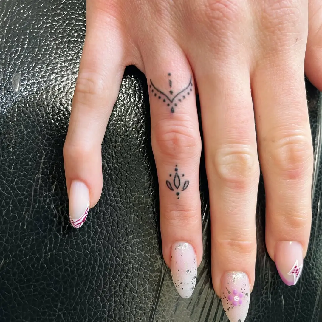 Photo d'une main dont les doigts sont tatoués avec la technique du handpoke
