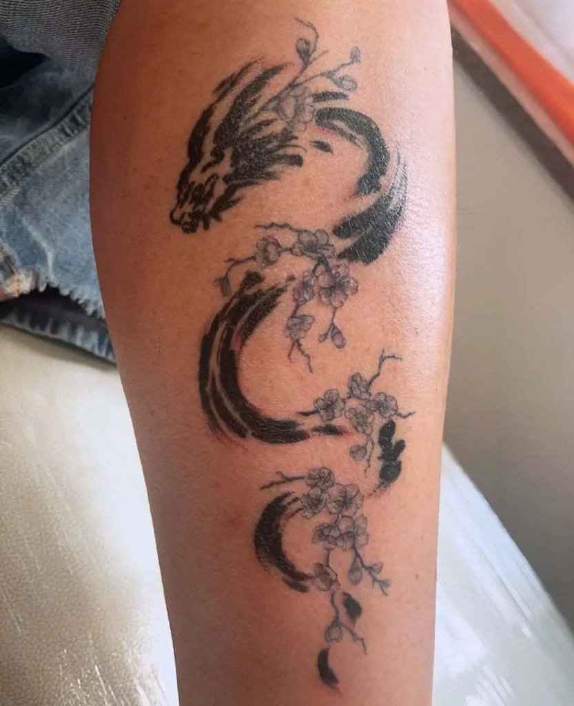 Photo d'un tatouage de dragon avec des fleurs bleues