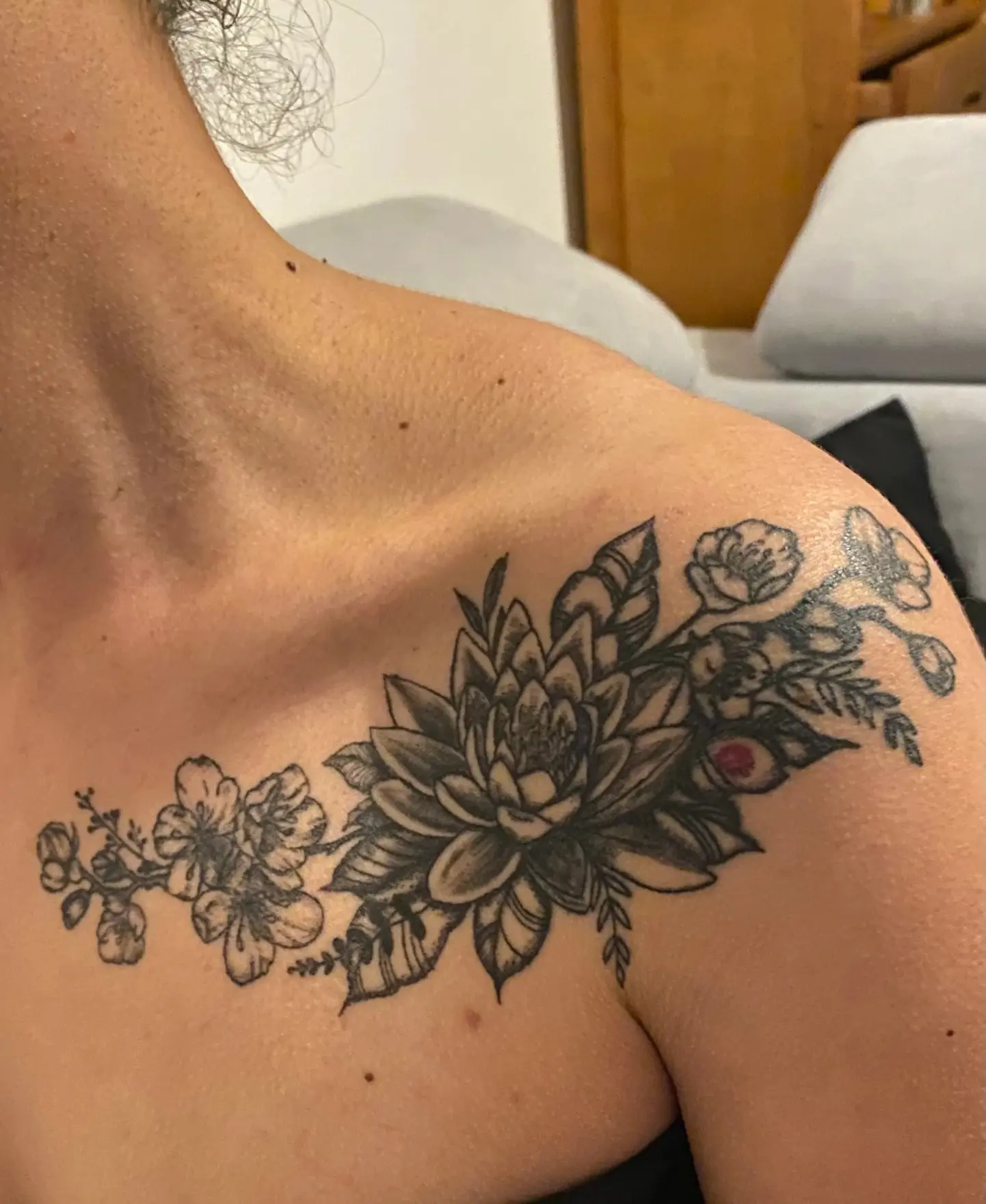 Photo d'un tatouage sur une épaule, représentant des fleurs