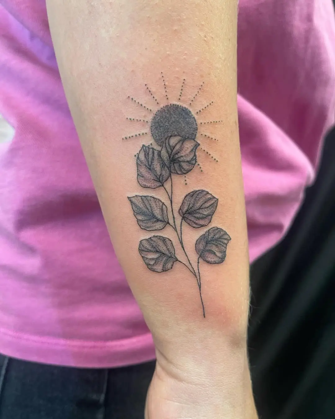 Photo d'un tatouage flash représentant un soleil et des feuilles