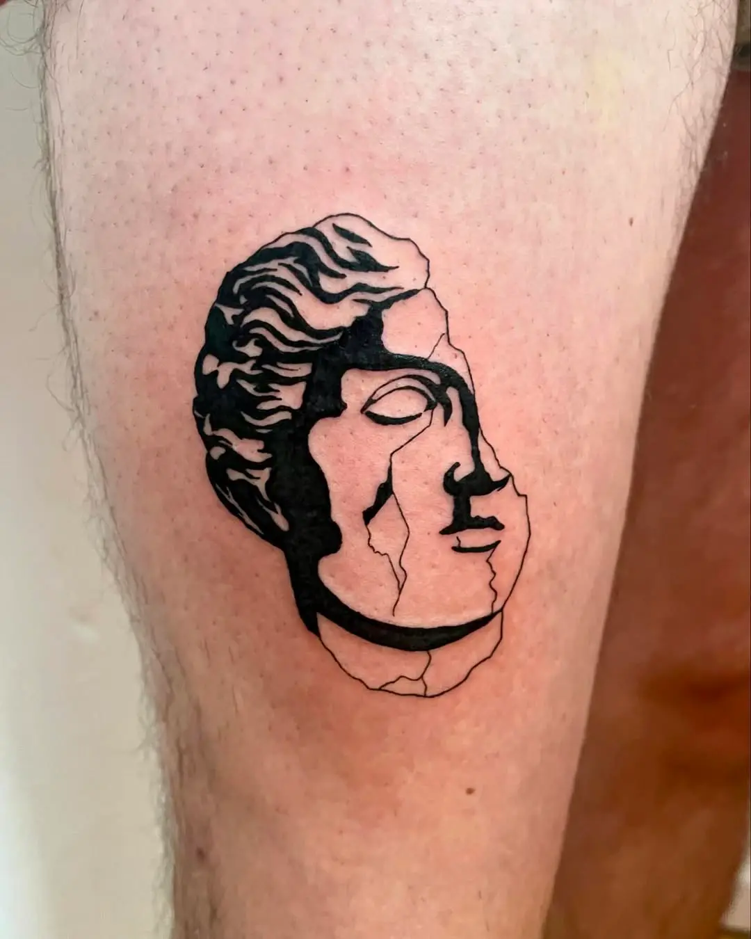 Photo d'un tatouage représentant une statue antique fissurée