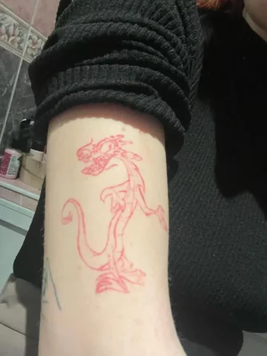 Photo d'un tatouage de dragon rouge qui s'efface