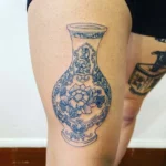 Photo d'un tatouage de vase bleu sur une cuisse