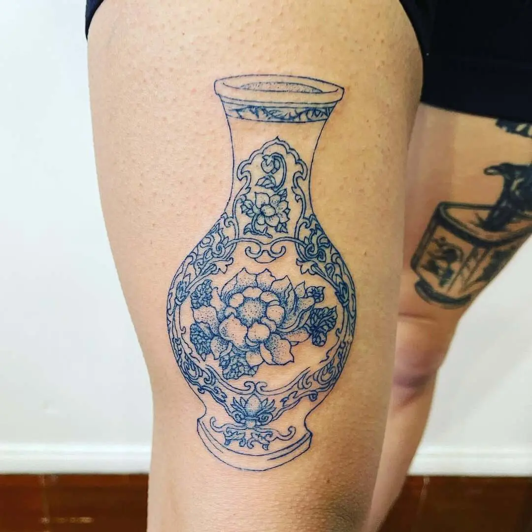 Photo d'un tatouage de vase bleu sur une cuisse