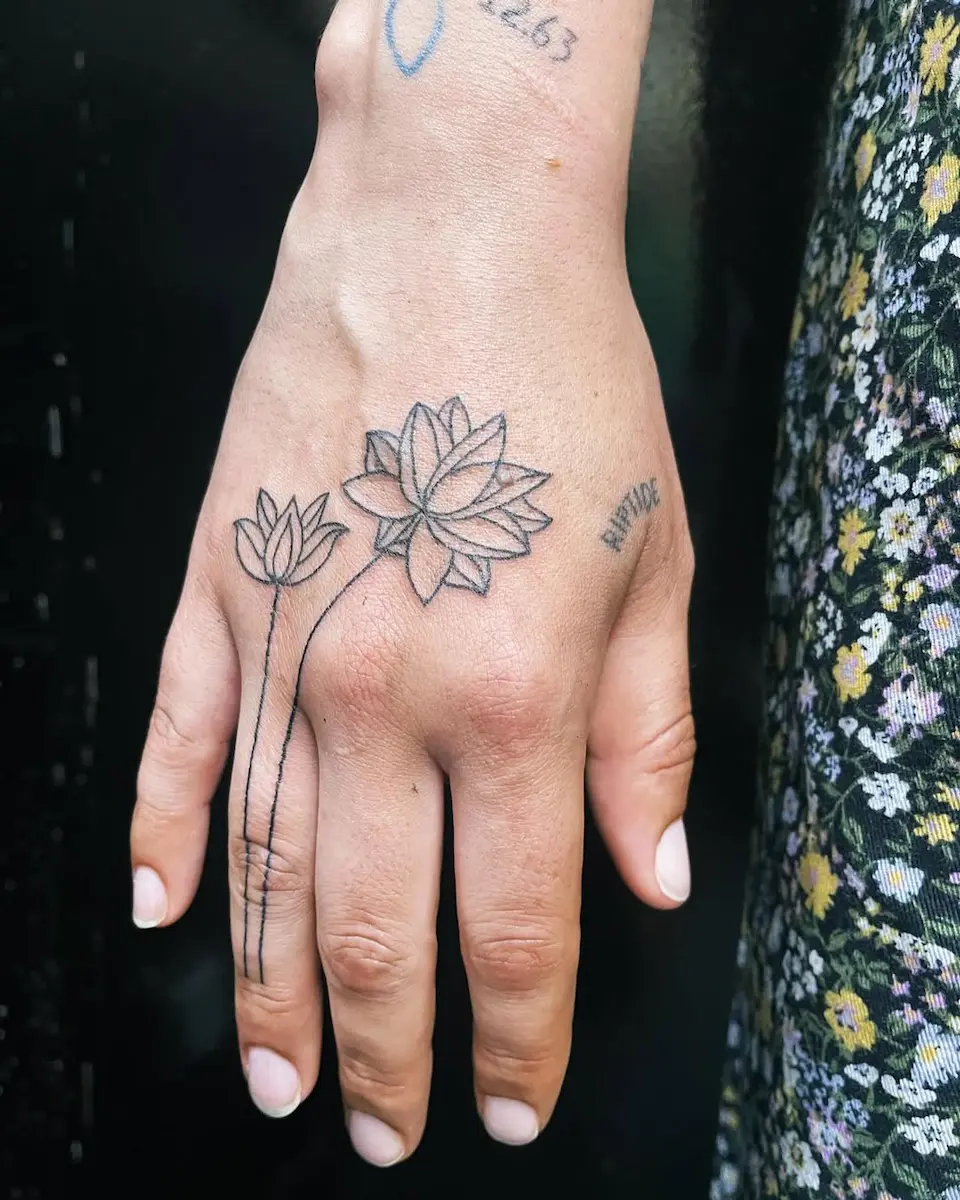 Lotus tatoué au handpoke sur les doigts et la main