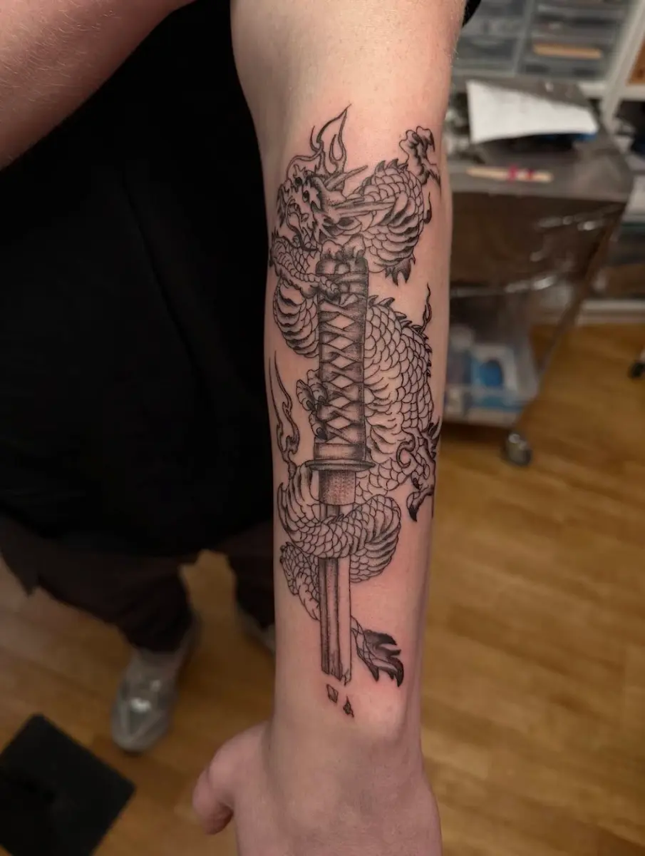 Tatouage de Guillaume représentant un dragon autour d'une épée