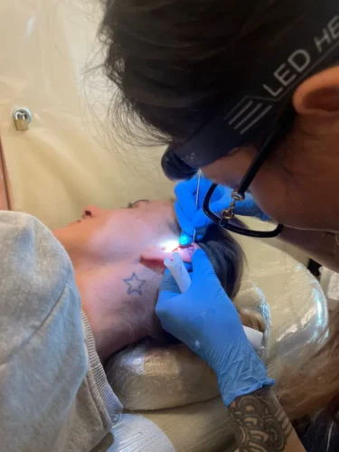 Juliette en pleine séance de handpoke (tatouage d'oreille).