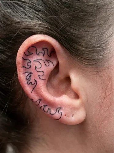 Tatouage d'un motif de flamme sur une oreille