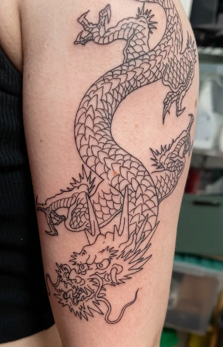 Photo d'un tatouage de dragon en ligne fine sur un bras