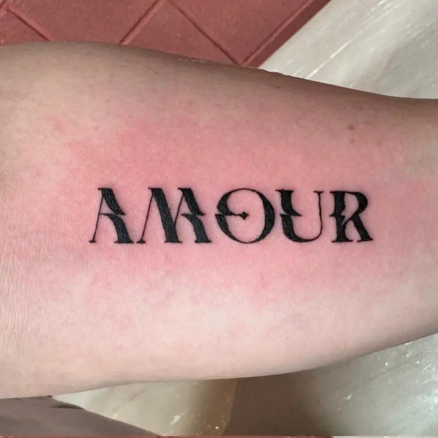 Photo d'un tatouage où il est écrit "amour"