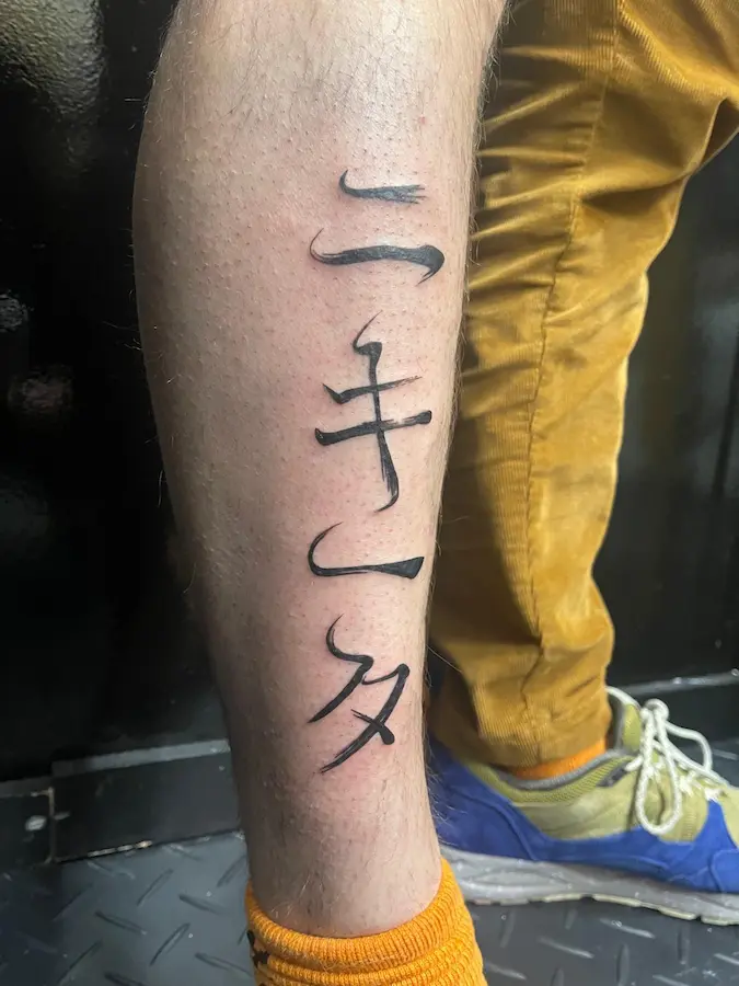 Tatouage calligraphie sur une jambe